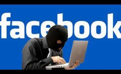 man with mask typing on a computer, name 'Facebook' in background
